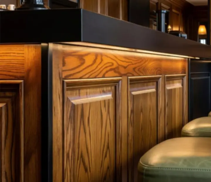 Detalles de interior en madera y tapicería oscura en el bar